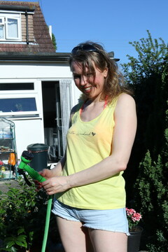 Hairy mature lady playing with the hose in the garden